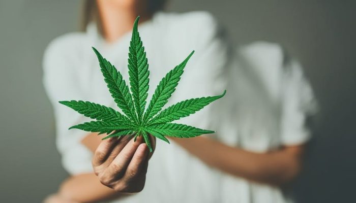 Woman holding a marijuana leaf for anxiety treatment